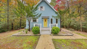 A light blue house with a yellow door, surrounded by trees with autumn foliage. - Lake Access, Tranquil Acreage: Farnham Cottage (Farnham)
