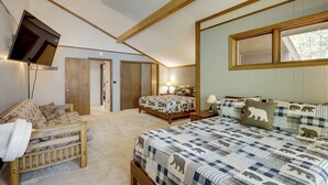 A bedroom with a large bed, a wooden chair, a television mounted on the wall, and a window. - Land O' Lakes Cabin on Big Portage w/ Fire Pit (Land O' Lakes)