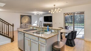 A modern kitchen with granite countertops, stainless steel appliances, and a large island. - Modern Resort Getaway 9 Mi to Disney Parks! (Kissimmee)