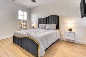 Ein Schlafzimmer mit Bett, Nachttischen und einem Fenster.