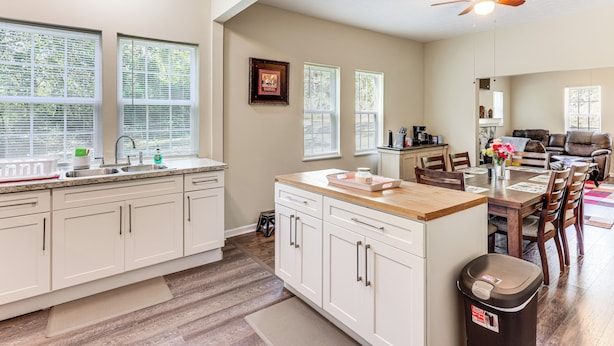 A spacious kitchen with white cabinets, a wooden countertop, and a ceiling fan. - 'Doris & Susan's Place' - Historic Tuskegee Home (Tuskegee)
