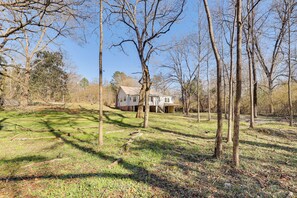 A house surrounded by trees and a grassy yard.