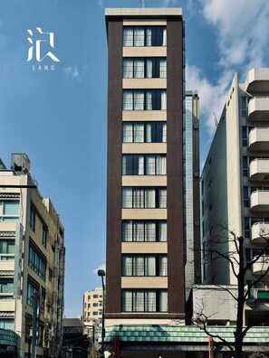 A modern high-rise building with multiple floors, large windows, and a prominent entrance at the base. - R98BB2E_501 / Taito-ku Tokyo (Taito-ku)