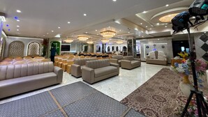 A spacious hall with multiple seating areas, including sofas and chairs, arranged for events. - Hotel Citrus (Lucknow)
