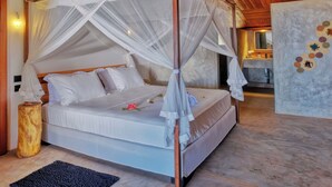 Una cama con dosel, ropa de cama blanca y una pared decorativa con diseños circulares.