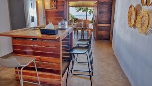 Una cocina con isla de madera, taburetes de bar y vistas al mar.