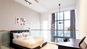 Une chambre moderne avec un lit, un bureau et une grande fenêtre.