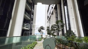 Un bâtiment moderne doté d’un couloir vitré, de plantes d’intérieur et d’un espace détente.