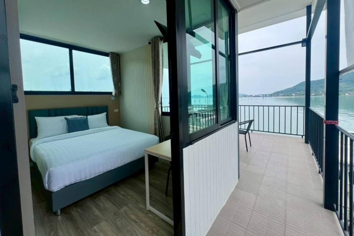 A balcony with a bed, a table, and a chair.