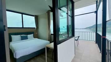 A balcony with a bed, a table, and a chair.