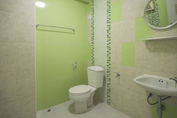 Un baño con inodoro, lavabo y zona de ducha.