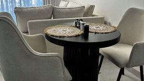 Moderni ruokailutila, jossa on pyöreä pöytä, neljä tuolia ja koristeellinen matto.