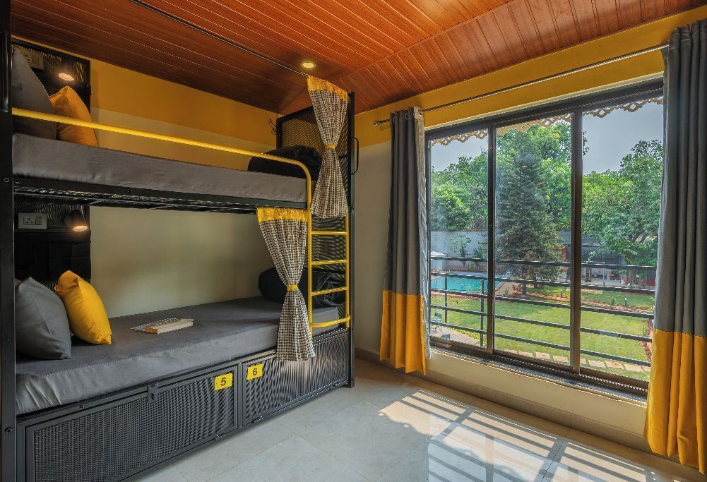 Dormitorio con literas y vista a un jardín.