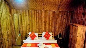 A room with a bed, wooden walls, and a door.