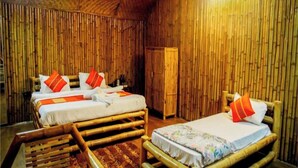 A room with two wooden beds, each with a pillow and a blanket.