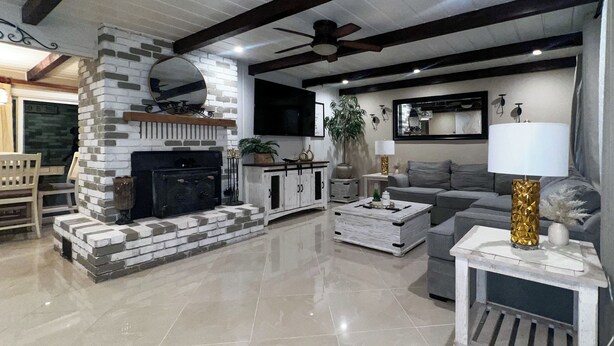 A modern living room with a fireplace, a sofa, a coffee table, and a lamp. - Cozy Corner on Carson (Burney)