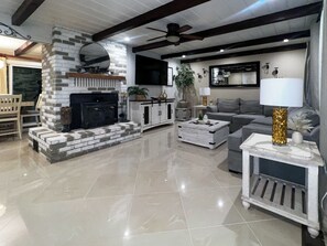 A modern living room with a fireplace, a sofa, a coffee table, and a lamp. - Cozy Corner on Carson (Burney)