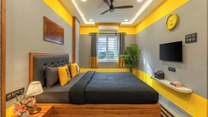 A modern bedroom with a bed, bedside table, lamp, and a TV on a shelf. - The Hosteller Hyderabad HITEC City (Hyderabad)