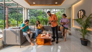 A modern living room with a sofa, coffee table, and potted plants. - The Hosteller Hyderabad HITEC City (Hyderabad)