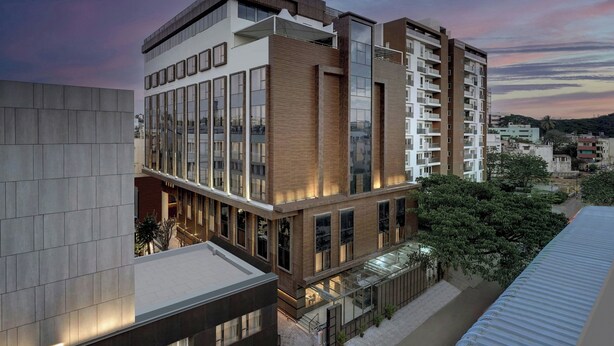 A multi-story building with a modern architectural design, featuring large windows and a mix of brick and glass facades. - The Fern Residency Bengaluru, Seshadripuram, Series by Marriott (Bengaluru)