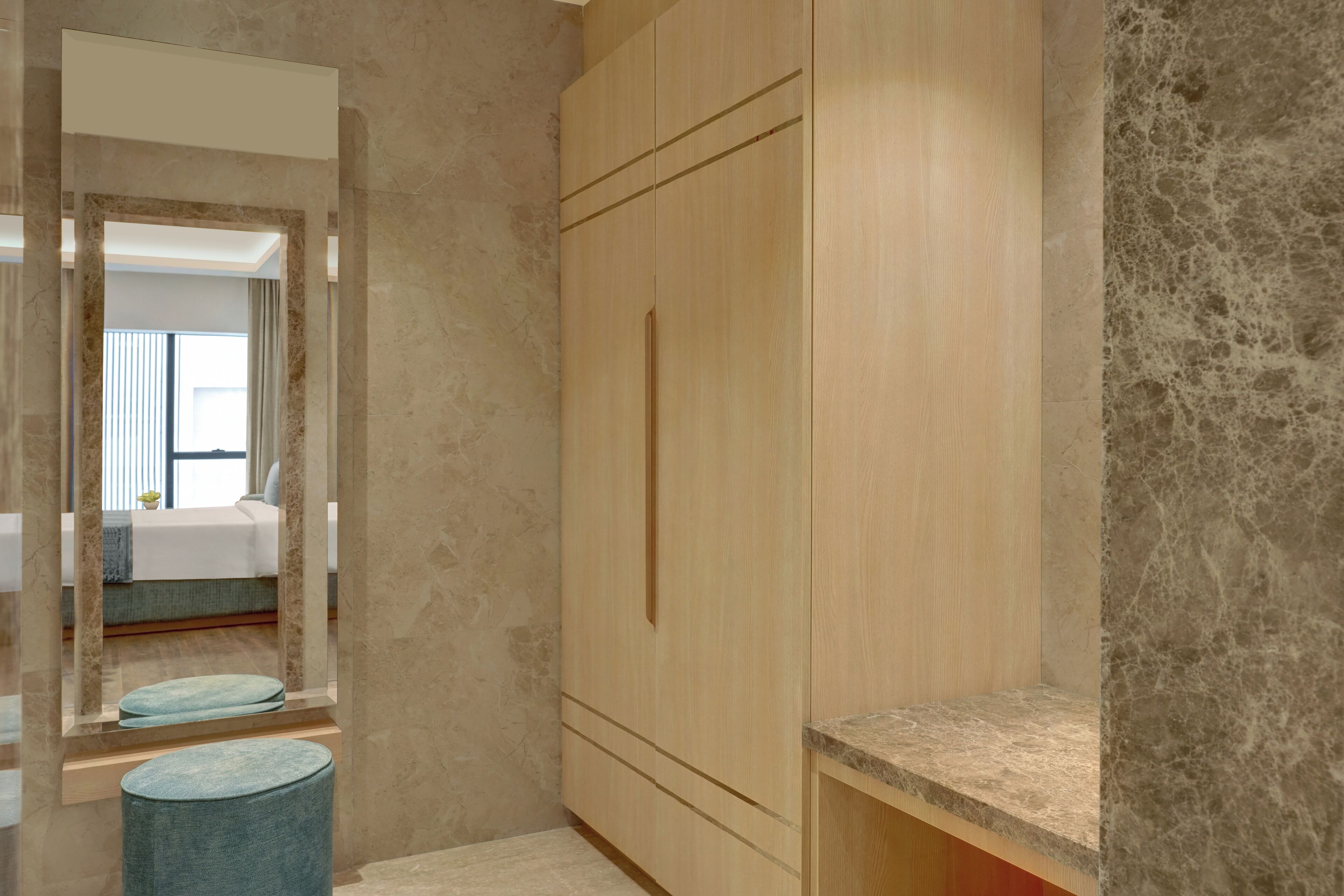 A modern bathroom with a marble floor, wooden cabinetry, and a mirror.