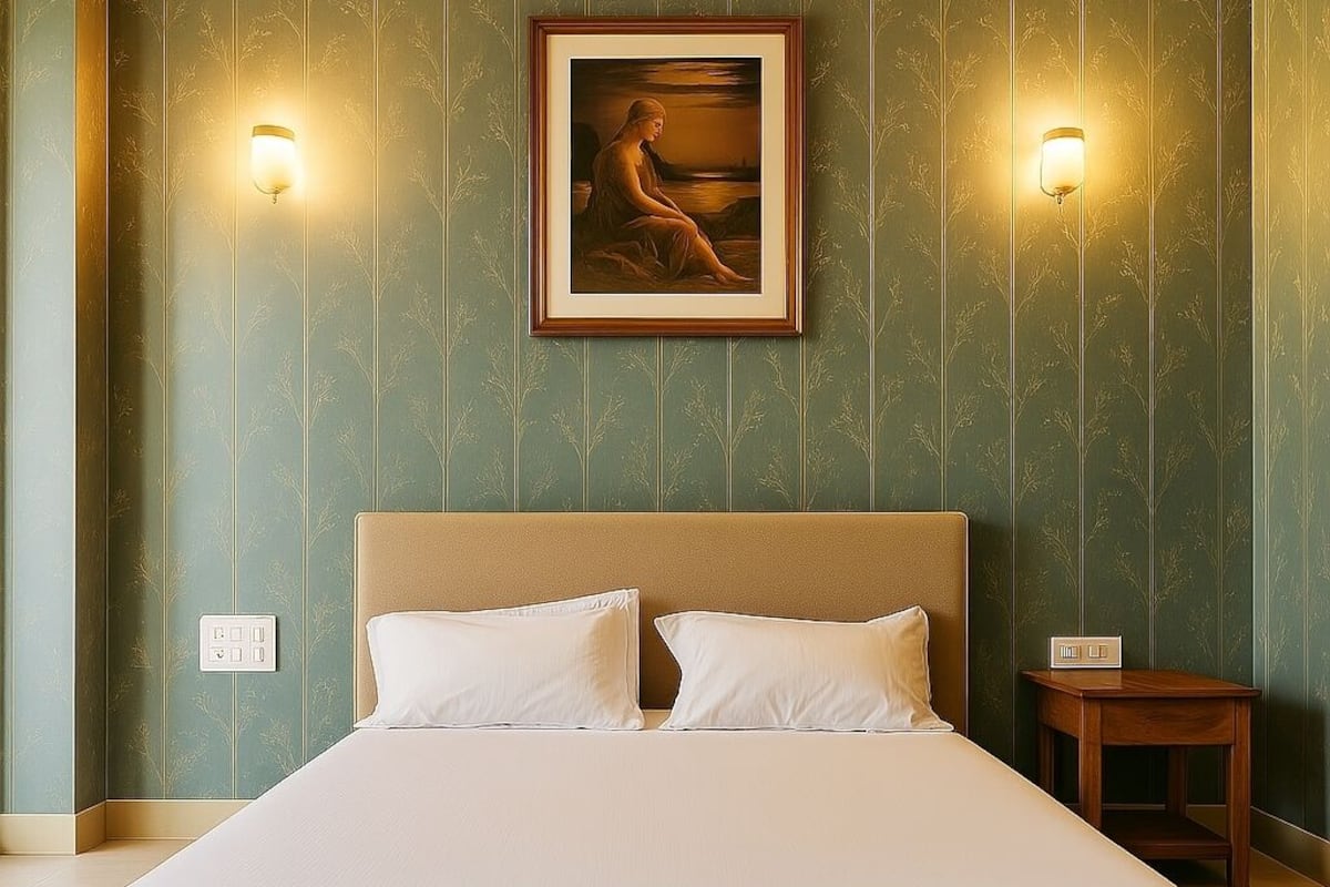 A neatly made bed with white linens, a wooden headboard, and two wall-mounted reading lamps.