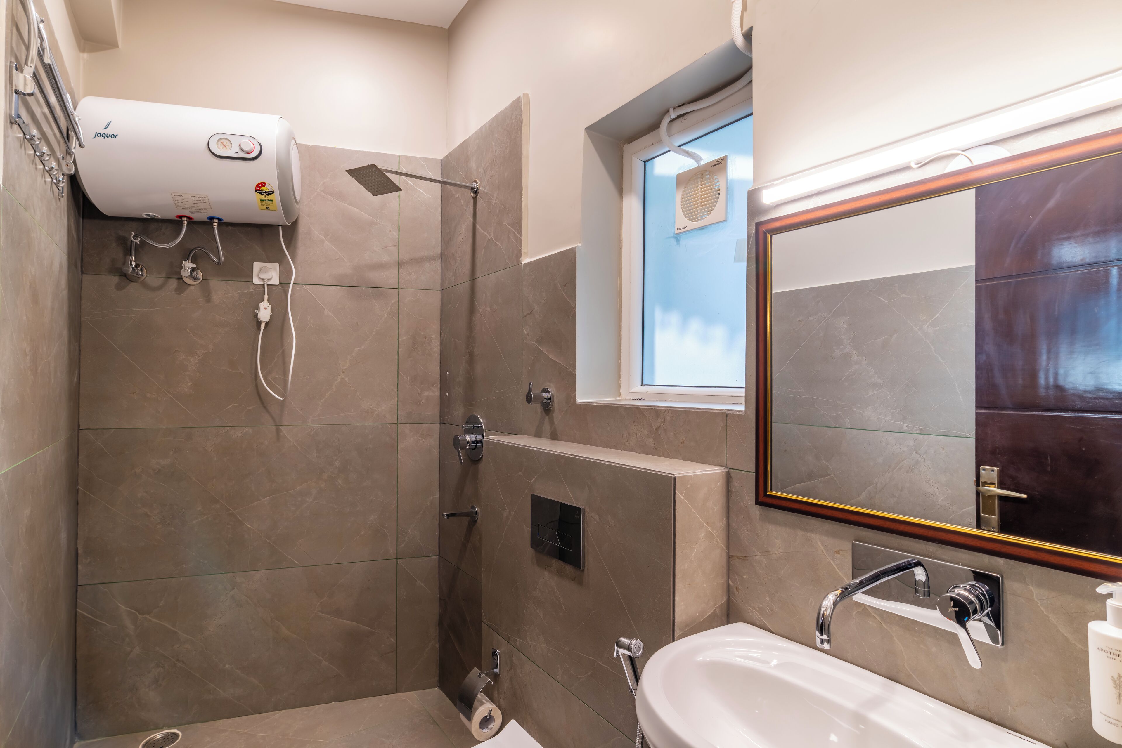Ein modernes Badezimmer mit barrierefreier Dusche, integriertem WC, Waschbecken und Spiegel.