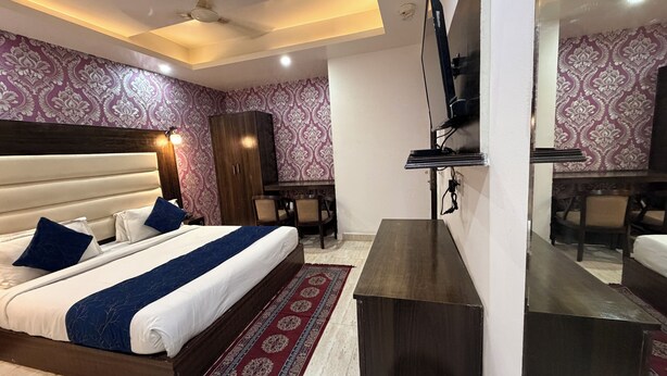 Habitación de hotel con una cama grande, un escritorio, un armario y un televisor.