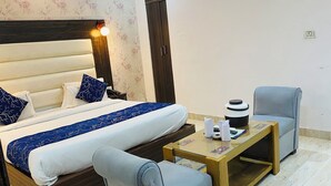 A hotel room with a bed, bedside table, chair, and a wardrobe. - Hotel The Raj Palace (New Delhi)
