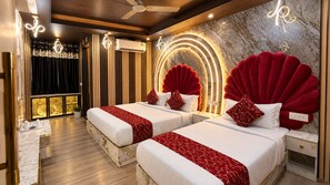A hotel room with two beds, a marble wall, and a ceiling fan. - Hotel The Raj Palace (New Delhi)