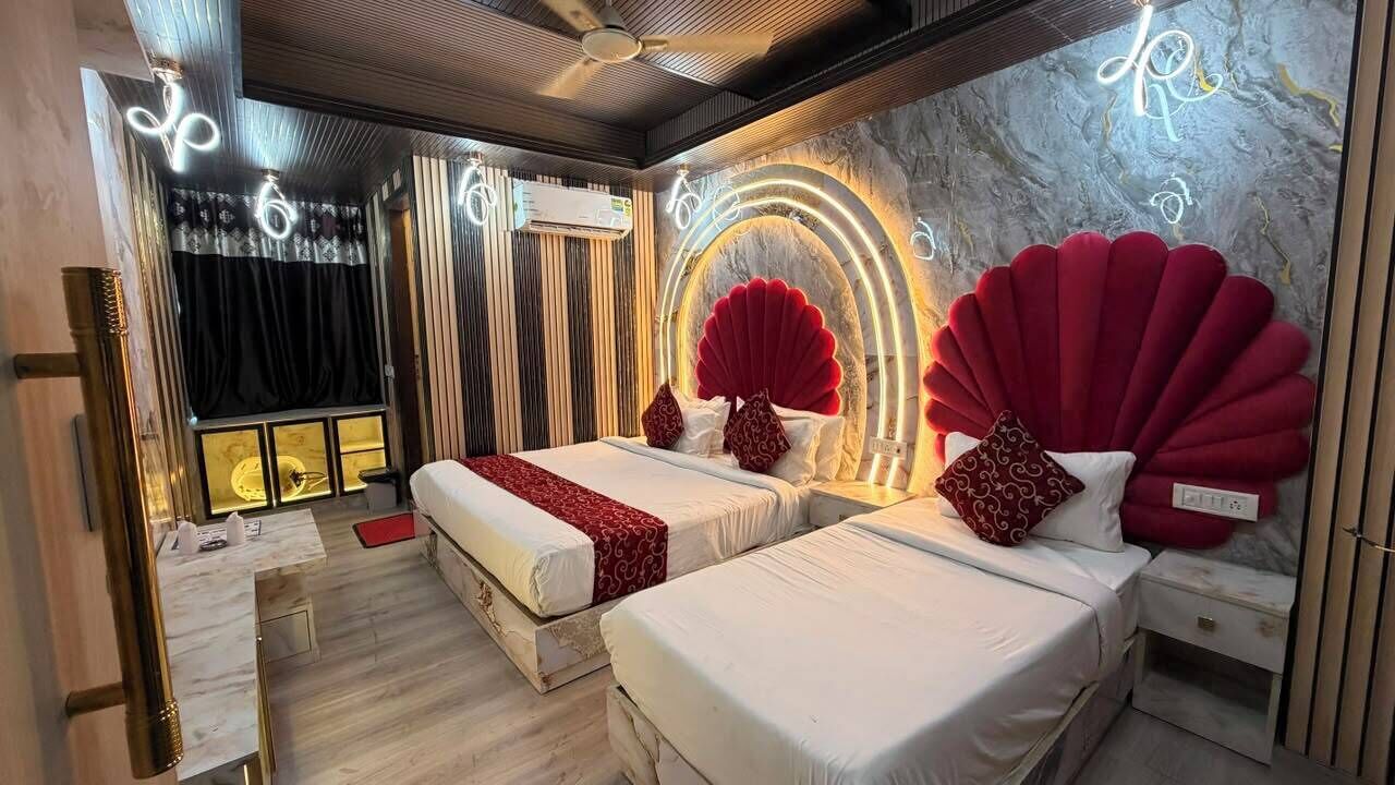 Une chambre d’hôtel avec deux lits, un mur en marbre et un panneau lumineux au néon.