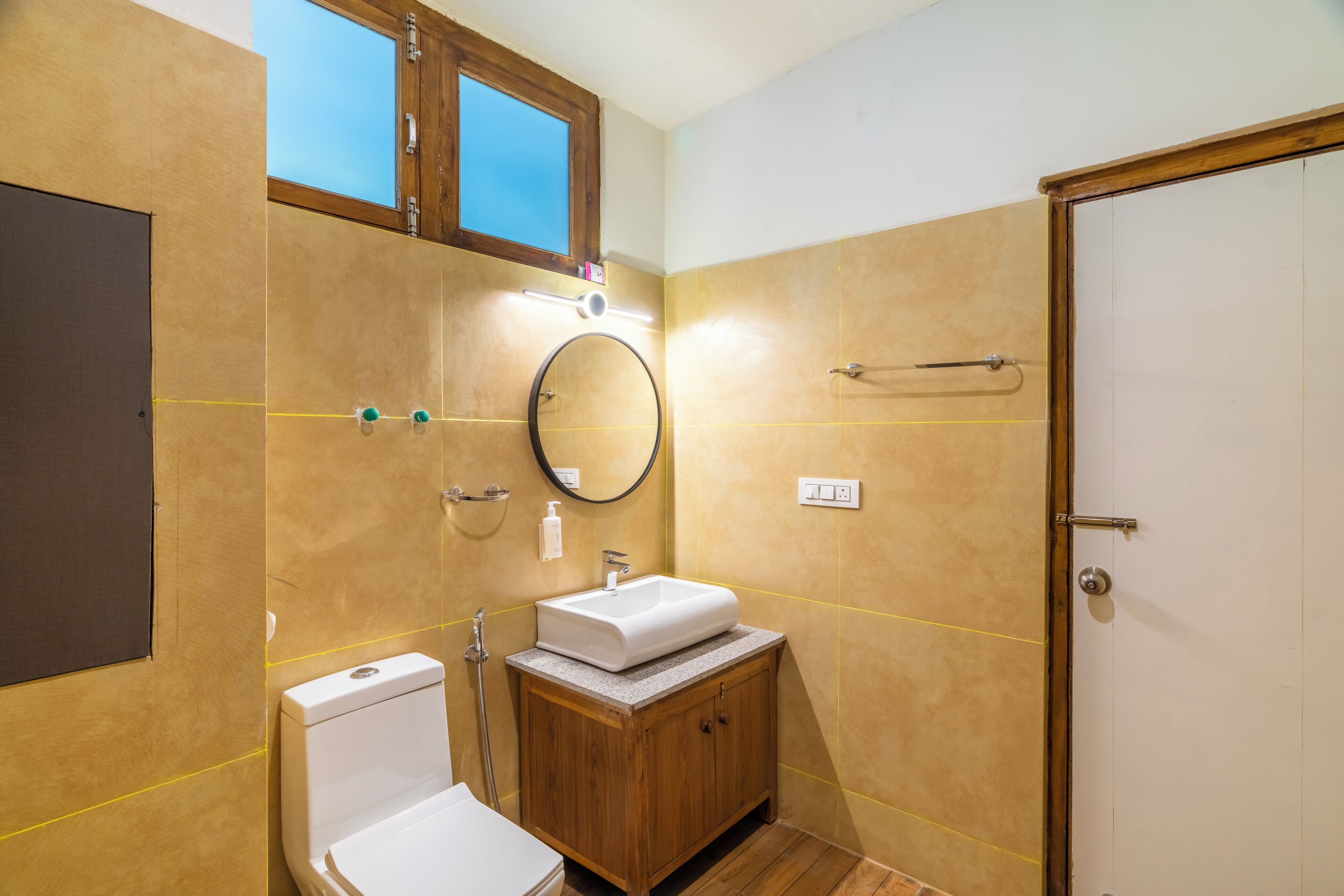 A bathroom with a toilet, sink, and mirror.