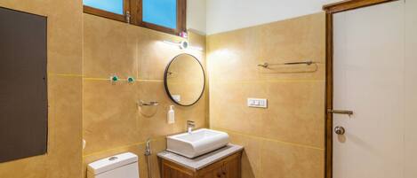 A bathroom with a toilet, sink, and mirror.