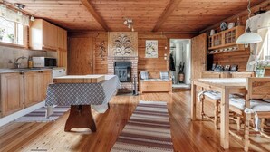 A rustic wooden interior with a kitchen, dining area, and fireplace. - A house by the forest with a stream and plenty of peace and quiet (Stenis)