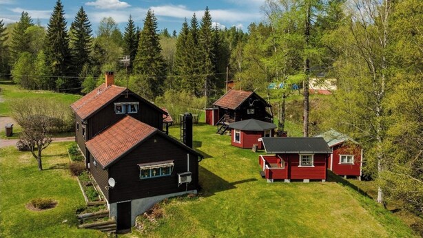 A cluster of cabins with a grassy yard and trees in the background. - A house by the forest with a stream and plenty of peace and quiet (Stenis)