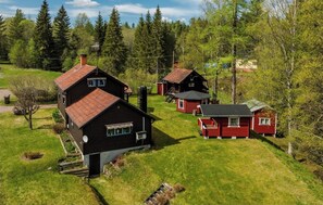 Un ensemble de chalets entourés d’une pelouse et avec des arbres en arrière-plan.