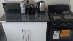 Eine Küche mit Mikrowelle, Toaster, Wasserkocher und Herd.