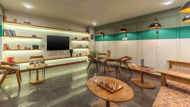 Zona relax moderna con schermo piatto, scaffali e sedute confortevoli.