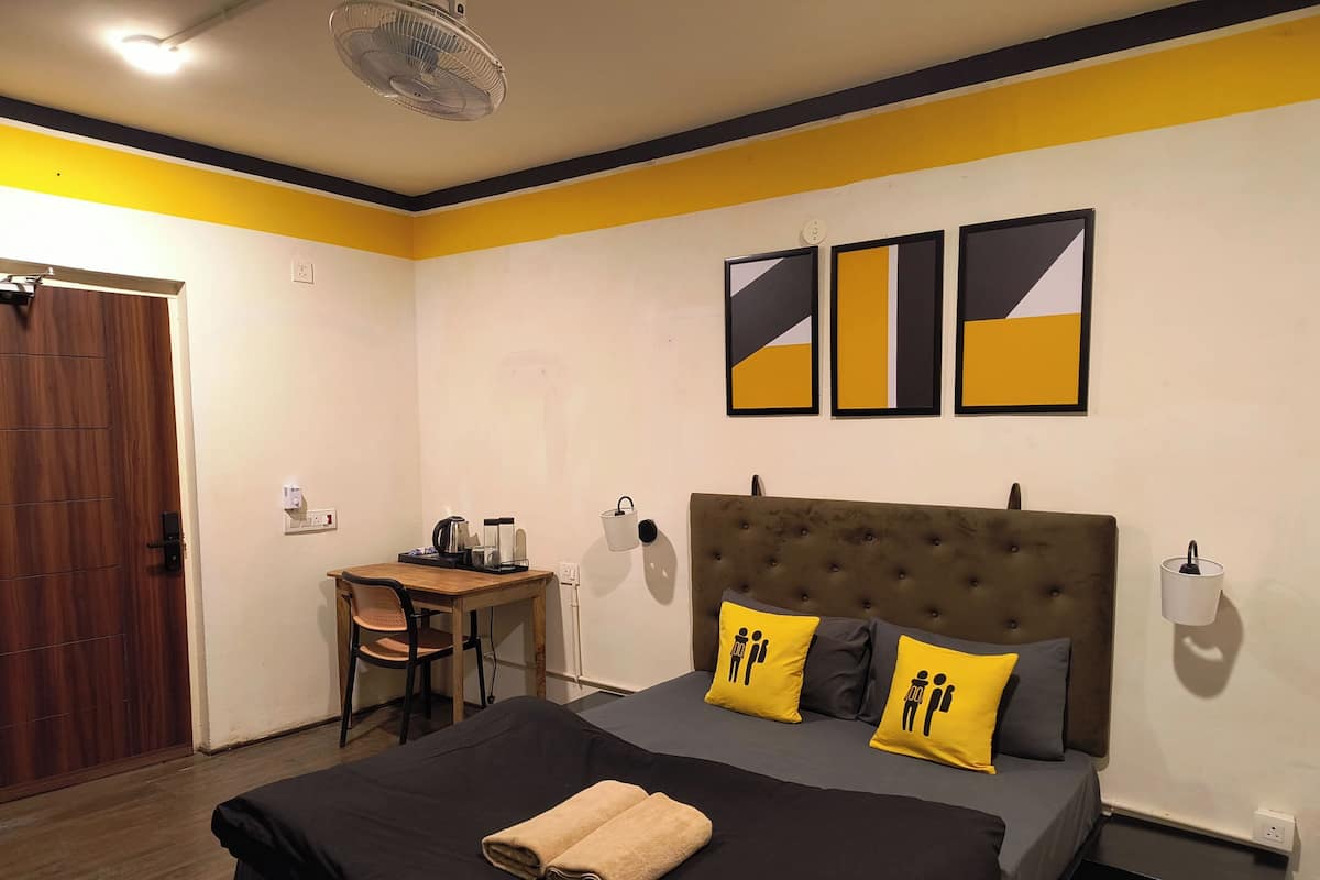 A bedroom with a bed, a desk, and a chair.