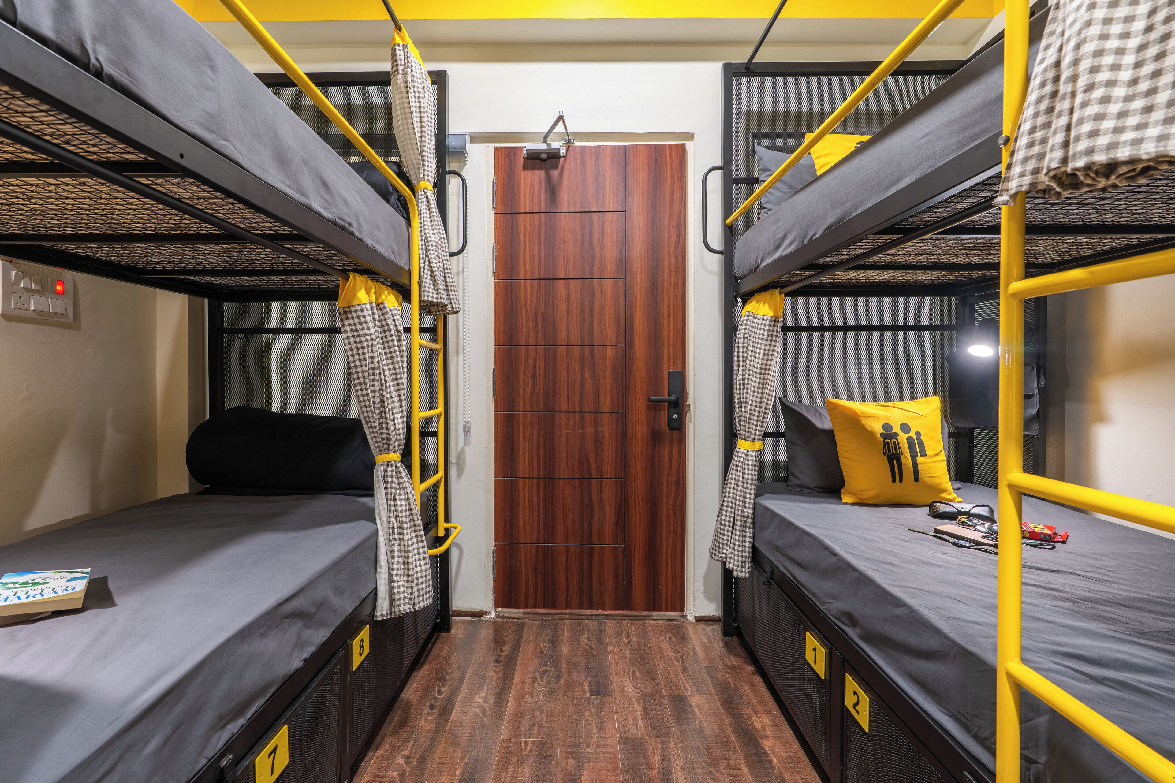Un dormitorio con literas, una puerta de madera y un ventanal pequeño.