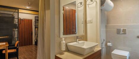 A modern bathroom with a large mirror, a sink, and a shower area.