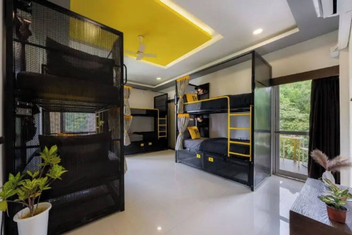 A modern hotel room with bunk beds, a balcony, and a ceiling fan.