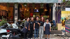 A group of people standing in front of a restaurant named "The Deck." - The Deck Toul Tompoung (Phnom Penh)