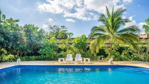 A swimming pool with lounge chairs and palm trees. - Samran Resort (Chalong)