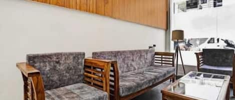 Una habitación con dos sofás tapizados en gris, una mesa de centro de madera y una lámpara.