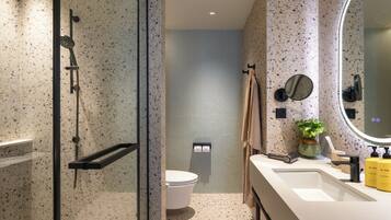 Ein modernes Badezimmer mit Dusche, Toilette und Waschbecken.