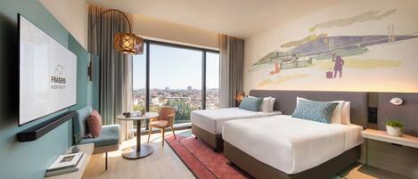 Une chambre d’hôtel avec deux lits, une télévision, un bureau, une chaise et une grande fenêtre donnant sur la ville.