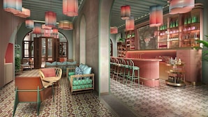 A bar area with a counter, bar stools, and shelves with bottles. - Capri by Fraser Penang (George Town)