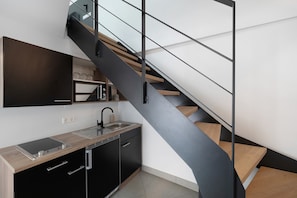 Een moderne keuken met een inbouwfornuis, een spoelbak en een zwart kastje.