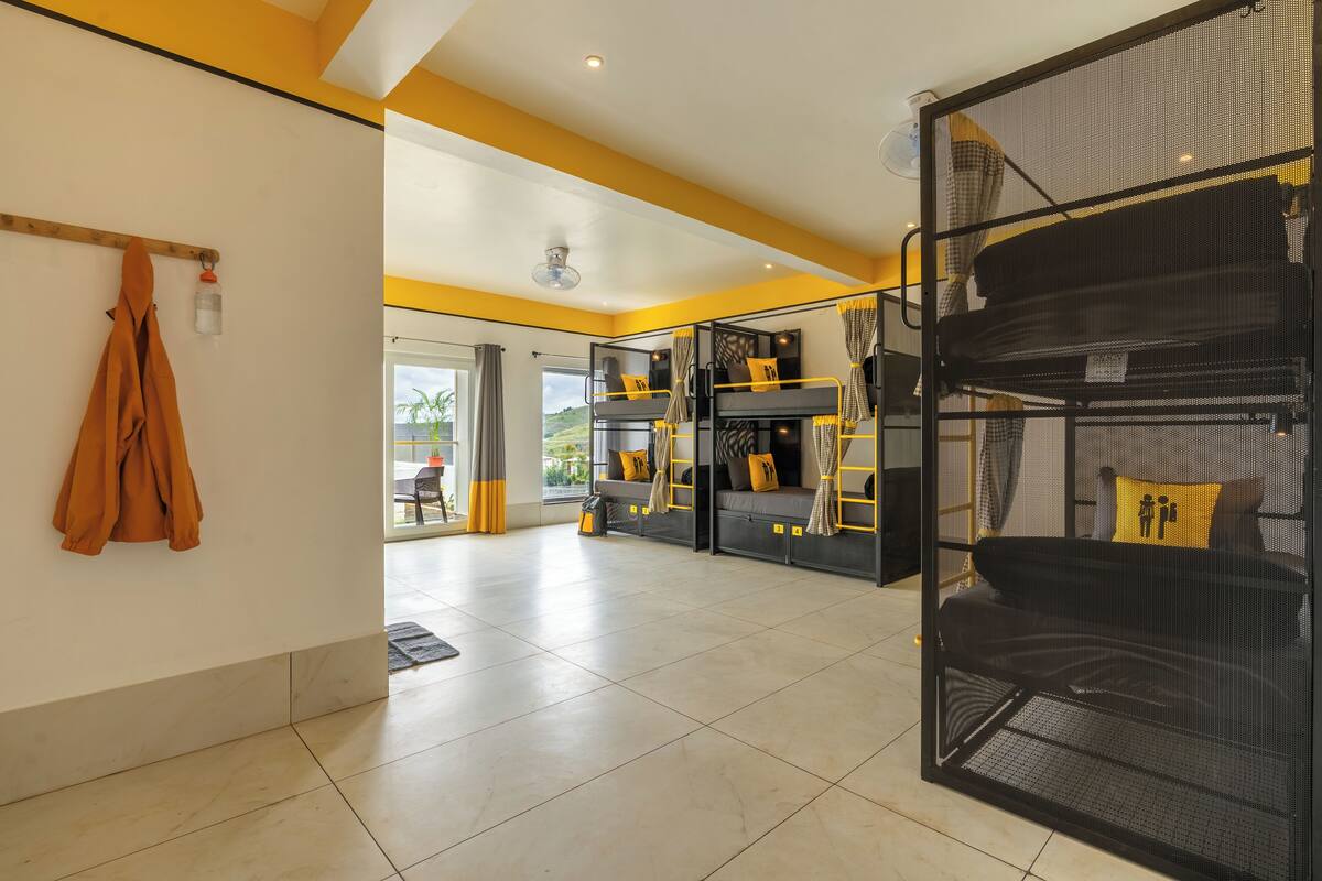 Ein modernes Hotelzimmer mit Stockbetten, einem Balkon und Blick ins Freie.